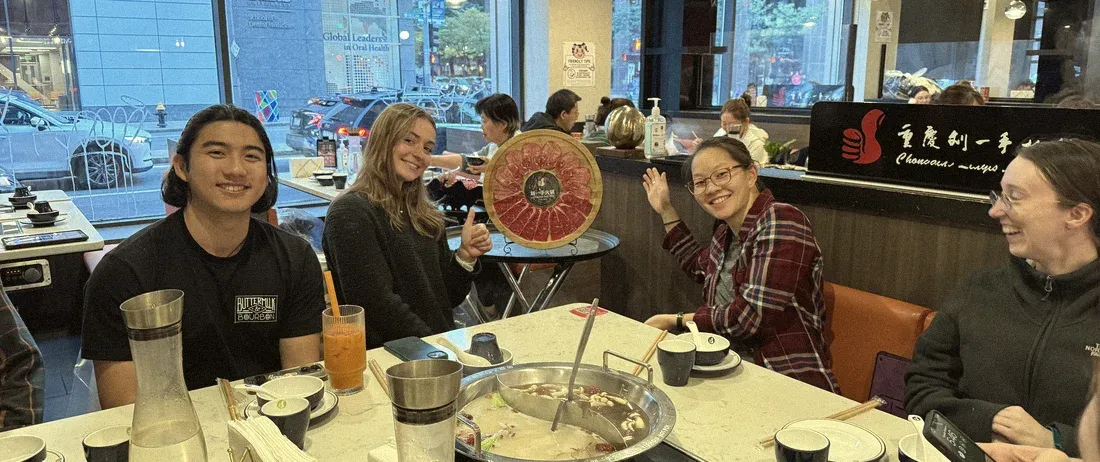 Teammates smiling around the hot pot table after the vision day
