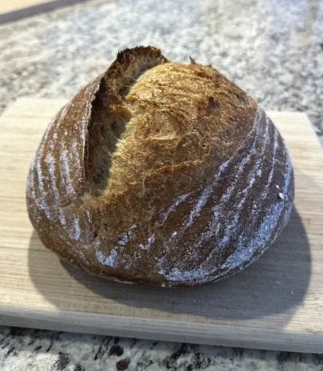 A homemade sourdough loaf on a cutting board